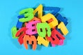 Heap of plastic colored numbers on a blue background