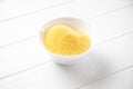 Heap of Polenta or Cornmeal Flour in a white bowl. Ground Dried Corn or Corn Grits. Healthy Grains Concept. Royalty Free Stock Photo