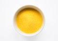 Heap of Polenta or Cornmeal Flour in a white bowl. Ground Dried Corn or Corn Grits. Top View, Copy Space. Healthy Grains Concept. Royalty Free Stock Photo