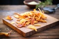 heap of potato skin peels on a rustic wooden board