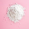 Heap of powder sugar on pink, from above