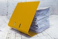 Heap of project drawings in yellow folder. Royalty Free Stock Photo