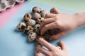 Heap of quail eggs and kids hands on color background. Vegetarian organic eco food