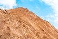 Heap in the quarry sand against the blue sky
