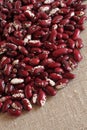 Heap of raw red with white speckled kidney beans on rough linen cloth Royalty Free Stock Photo