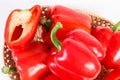 Heap of red peppers in wicker basket on white background, healthy nutrition Royalty Free Stock Photo