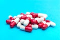 Heap of red-white capsules on blue background Royalty Free Stock Photo