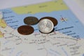 Heap of Rial Omani money coin put on the map near Muscat city. Concept of finance or travel