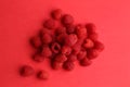 Heap of ripe red raspberries on red surface Royalty Free Stock Photo