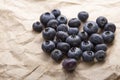Heap ripe sweet blueberries on rustic paper top view