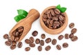 Heap of roasted coffee beans in wooden bowl with leaves isolated on white background with clipping path and full depth Royalty Free Stock Photo