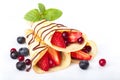 Heap of rolled pancakes with berries isolated on