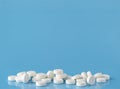 Heap of round white pills. Blue background with text space Royalty Free Stock Photo