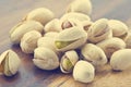 Heap salted pistachio nuts on wooden background