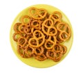 Heap of salted pretzels in yellow saucer isolated on white Royalty Free Stock Photo