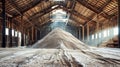 A heap of sand sits majestically in a barn amidst a warehouse of potash fertilizers, symbolizing the timeless cycle of mining and
