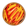 A heap of sliced bell peppers, sweet peppers, capsicum in a wooden bowl