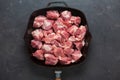 Heap small pieces raw meat in frying pan