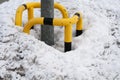 A heap of snow at a post of a street light