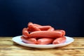 Sausages in a package lies on a white plate Royalty Free Stock Photo