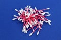 A bunch of cotton buds lie on a blue background.