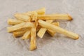 Heap of sticks of french fries on gray crumpled paper Royalty Free Stock Photo