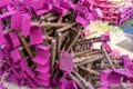 A heap of support material steel covering by pink rustproof paint, on the concrete floor in front the building in construction