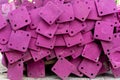 A heap of support material steel covering by pink rustproof paint, on the concrete floor in front the building in construction