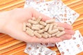 Heap of tablets in hand and empty pills blisters Royalty Free Stock Photo