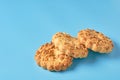 Heap of three fresh circle oat cookies with hole and peanuts lies on blue desk on kitchen