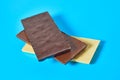 Heap of three various whole porous chocolate bars lies on blue table on kitchen