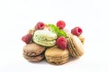 Heap of traditional french macaroons and raspberries, mint leaf