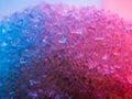 Heap of transparent white sugar crystals in mixed colour light. Macro photo