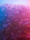 Heap of transparent white sugar crystals in mixed colour light. Macro photo