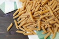 Uncooked Dried Whole Wheat Penne Rigate Pasta on Wooden Table Royalty Free Stock Photo