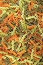 Heap of uncooked three-color fusilli pasta for backdrop Royalty Free Stock Photo