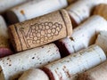 Heap of used wine corks. Bunch of grape drawing on one wine cork. Horizontal Royalty Free Stock Photo