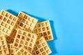 Heap of vanilla belgian waffles on blue background