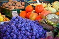 A heap of violet prunes, some orange pumpkins and Sunflowers on a table at the market