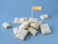 Heap of white chocolate cubes with the sign of a dangerous additive e171