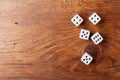 Heap of white dice on rustic wooden table top view. Gambling devices. Game of chance concept.