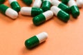 Heap of White and green capsules on orange background. One pill Royalty Free Stock Photo