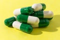 Heap of white and green capsules on white background. Pile of pi Royalty Free Stock Photo