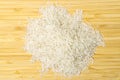 Heap of white long basmati rice on bamboo table