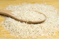 Heap of white long basmati rice with a spoon on bamboo table