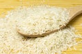 Heap of white long basmati rice with a spoon on bamboo wooden table. Gluten free traditional asian food