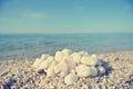 Heap of white pebbles on pebbly beach; faded, retro style Royalty Free Stock Photo
