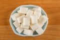 Heap of sugar cubes in blue bowl on wooden table. Top view Royalty Free Stock Photo