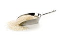 Heap of white uncooked, raw long grain rice in metal scoop on white
