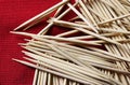 A HEAP OF WOODEN TOOTHPICKS ON A RED CLOTH